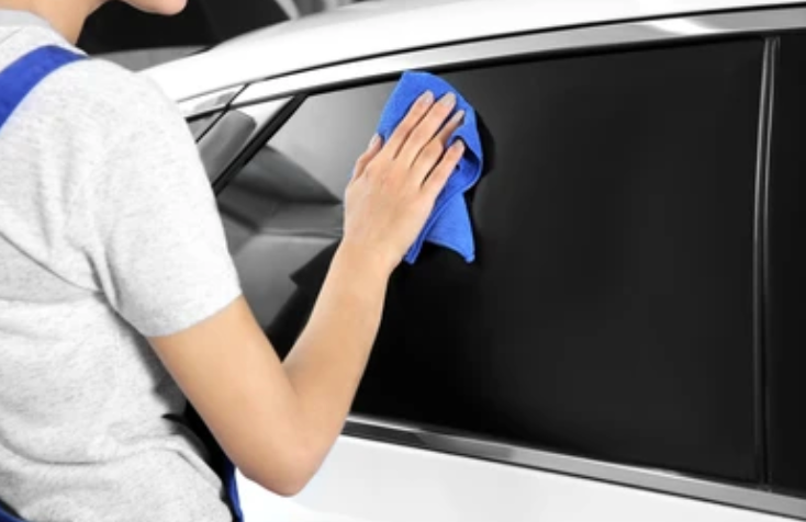 Person Carefully Cleaning Tinted Windows